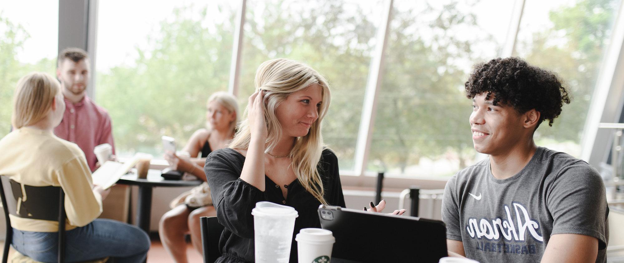 Two students talk about admissions requirements in the Student Union.